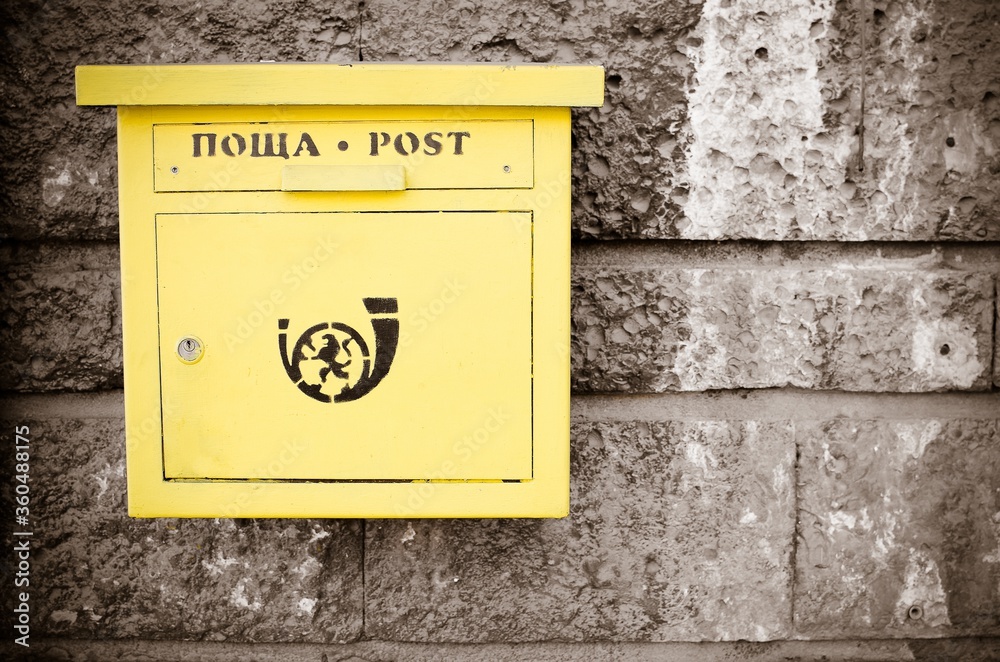 yellow post box on wall