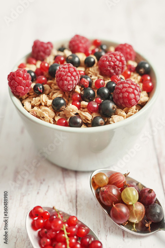 Colorful fresh berries on white background. Oatmeal with berries currants  raspberries  gooseberries. Vitamins  Diet. Copy space. Healthly food  detox. Cozy good morning  Summer Healthy breakfast