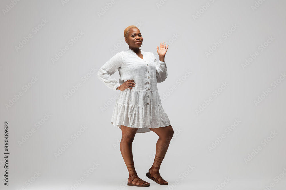 Greeting. Young woman in casual wear on gray background. Bodypositive character, feminism, loving herself, beauty concept. Plus size businesswoman, beautiful girl. Inclusion, diversity. Greeting. Young woman in casual wear on gray background. Bodypositive character, feminism, loving herself, beauty concept. Plus size businesswoman, beautiful girl. Inclusion, diversity.