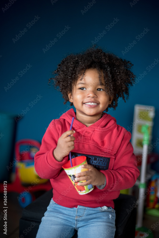 Bimba Africana Casa sorrisi succo di frutta sorrisi Stock Photo | Adobe  Stock