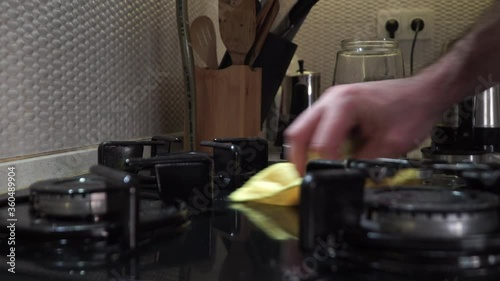 Close up of man cleaning cooker at home kitchen.Cleaning a gas stove with kitchen utensils, household concepts, or hygiene and cleaning.	 photo