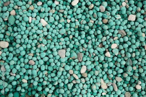 Little mint color pebbles texture. Small colorful round rocks or stones decor. Close up shot. Abstract background, pattern or wallpaper.