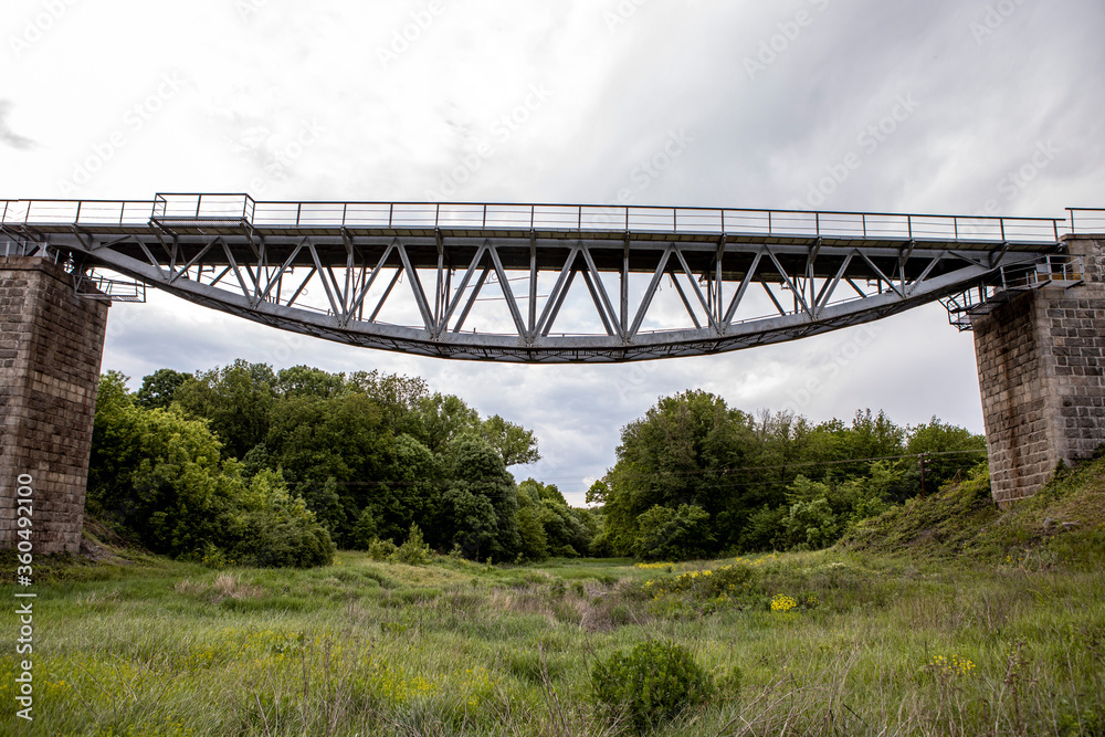 Obraz premium The beautiful high railway bridge. Metal construction