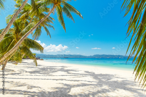 Beautiful landscape of tropical beach on Boracay island, Philippines. Coconut palm trees, sea, sailboat and white sand. Nature view. Summer vacation concept. © frolova_elena