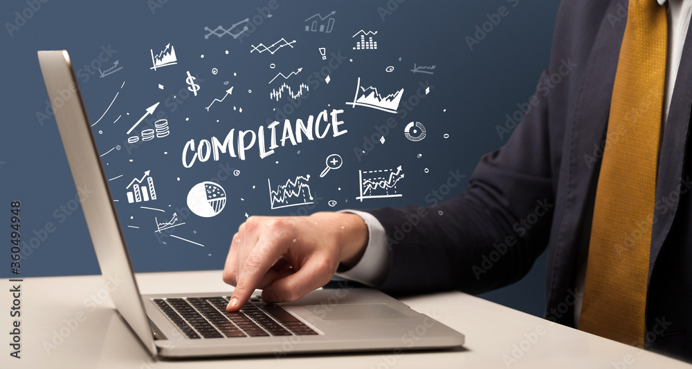 Businessman working on laptop with COMPLIANCE inscription, modern business concept Businessman working on laptop with COMPLIANCE inscription, modern business concept