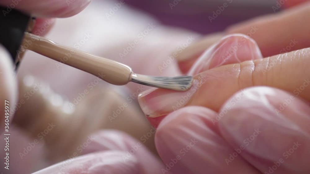 	
Manicurist doing manicure client painting nails with nail polish	
