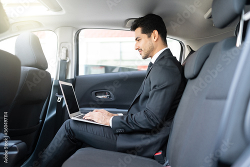 Young Businessman Using Laptop In Taxi © AntonioDiaz