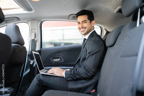 Smiling Businessman Using Laptop In Taxi © AntonioDiaz