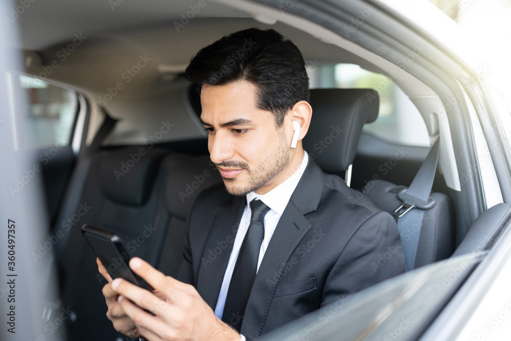 Young Businessman Using Smartphone In Car