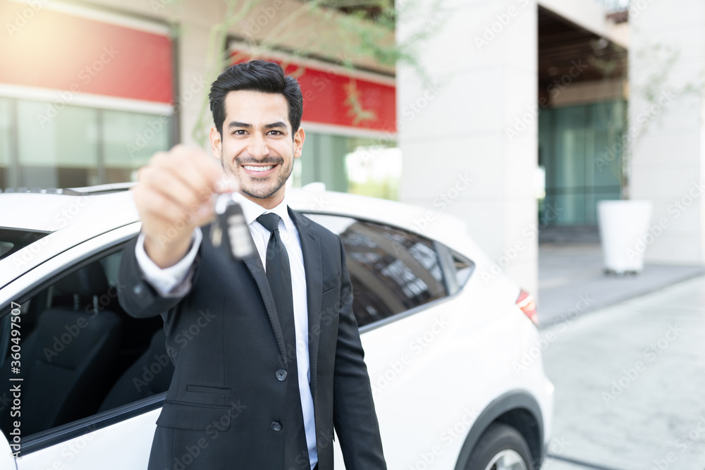 Confident Male Dealer Showing Car Key