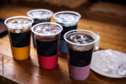 variant of cold drinks with fruit flavor. fresh cafe menu with dark background. colorful ice mockups with plastic cups. grape  chocolate  strawberry  mango  grass jelly   blueberries  guava