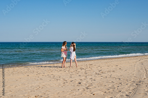 Two girls talking on the shore