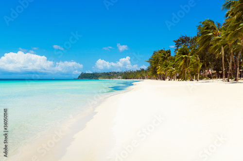 Beautiful landscape of tropical beach on Boracay island, Philippines under lockdoun. Coconut palm trees, sea, sailboat and white sand. Nature view. Summer vacation concept. © frolova_elena