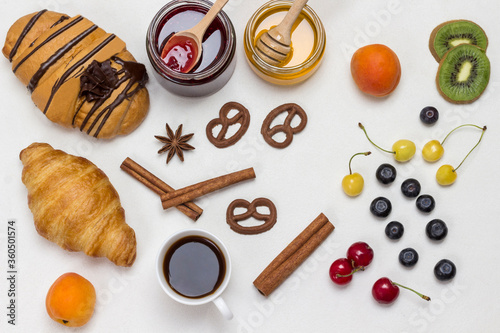 Fototapeta Naklejka Na Ścianę i Meble -  Croissants and figured cookies, berries, apricots honey, jam, cinnamon.