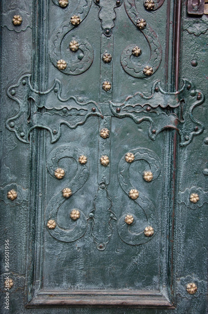 Wrought iron elements on an old metal gate background Wrought iron elements on an old metal gate background