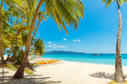 Beautiful landscape of tropical beach on Boracay island  Philippines. Coconut palm trees  sea  sailboat and white sand. Nature view. Summer vacation concept.