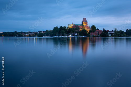 Ratzeburg Dome peninsula in golden light at blue hour evening with reflection in the water, Schleswig-Holstein, Germany
