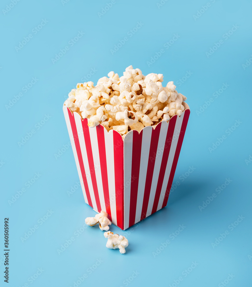 classic red and white box of popcorn isolated on blue
