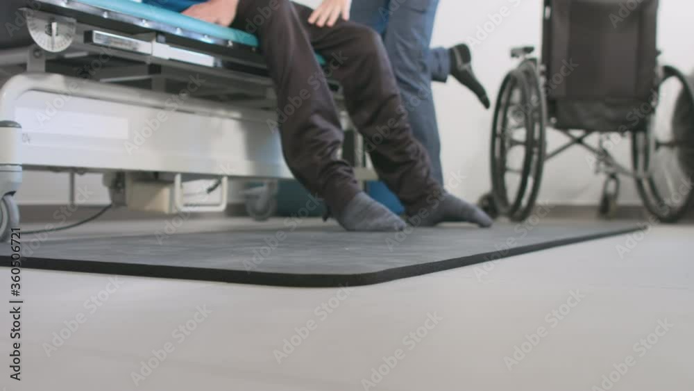 Physiotherapist exercising with disabled person on a therapy table. Physiotherapist exercising with disabled person on a therapy table.