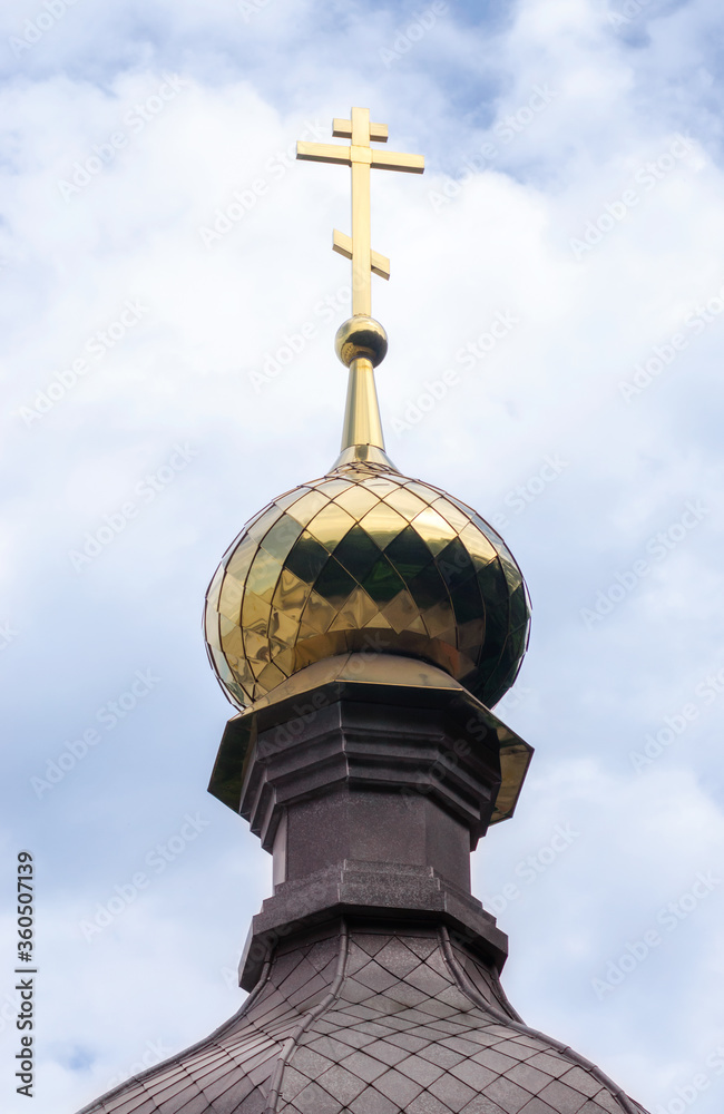 bottom view golden domes of christian church with crosses on blue sky background