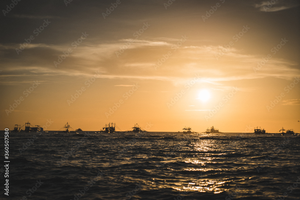 Fototapeta premium Boats sunset over the sea
