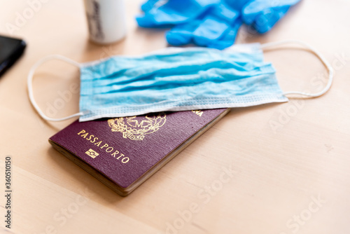 corona virus travel and tourism concept, italian passport and face mask as symbol of the traveling industry crisis and the new safety measures after the virus global outbreak photo