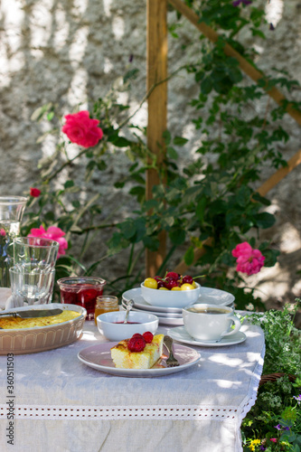 Breakfast in the garden from casseroles, berries, sauces and drinks. Rustic style.