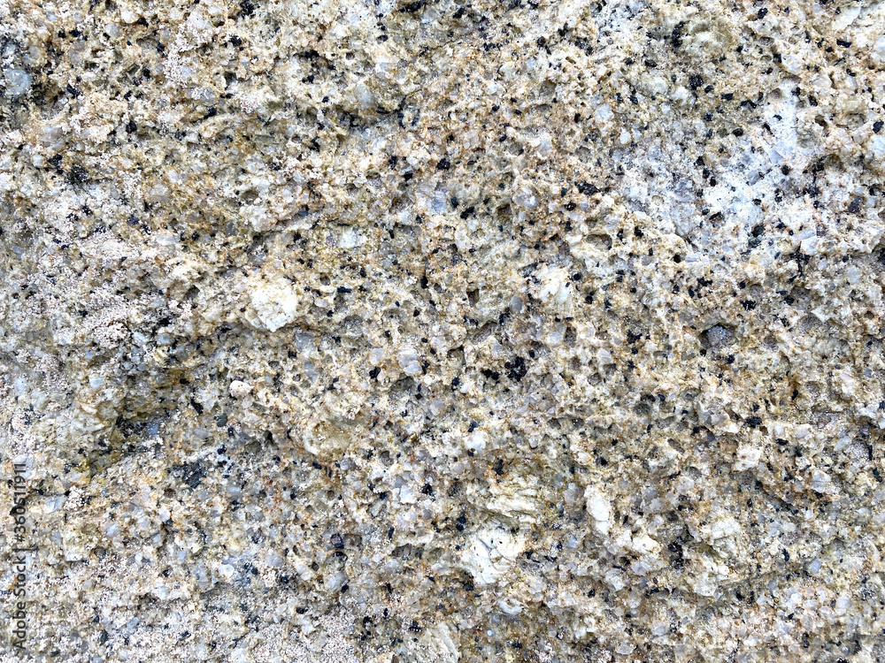 Close-up shot of a large rock with a white and gold dividing beside the sea that has been eroded by the sea until it is beautiful for artwork or graphic design. wallpaper, background, or backdrop. Close-up shot of a large rock with a white and gold dividing beside the sea that has been eroded by the sea until it is beautiful for artwork or graphic design. wallpaper, background, or backdrop.