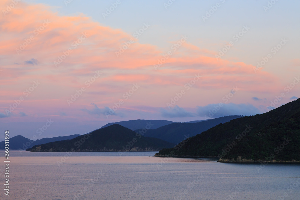 Sunset clouds over a mountainous coastline. Queen Charlotte Sound, New Zealand