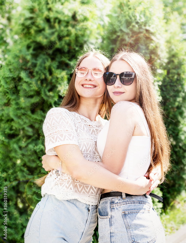 Fototapeta premium Happy girlfriends hugging together outdoors