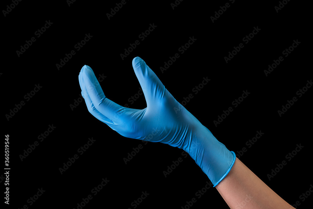 Doctor's hand in sterile medical gloves showing something isolated on black Doctor's hand in sterile medical gloves showing something isolated on black