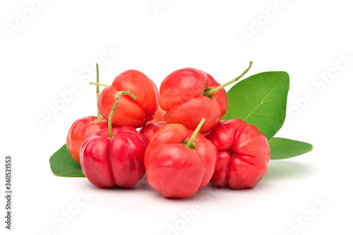 Pile of ripe Acerola cherry with green leaves isolated on white background.