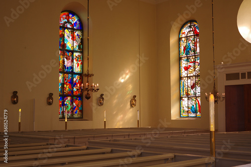 Sunlight throught beautiful stained glass windows in empty church photo