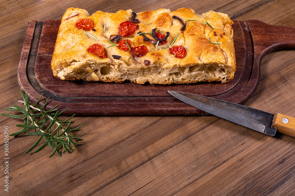 Traditional Italian Focaccia with cherry tomatoes, black olives and rosemary