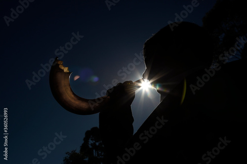 
Man blowing Shofar, horn used as a musical instrument by Jews photo