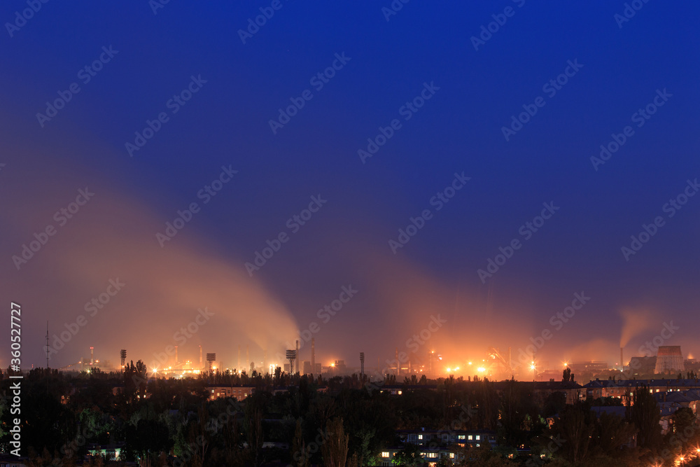 Evening in the city with a large metallurgical plant on the outskirts