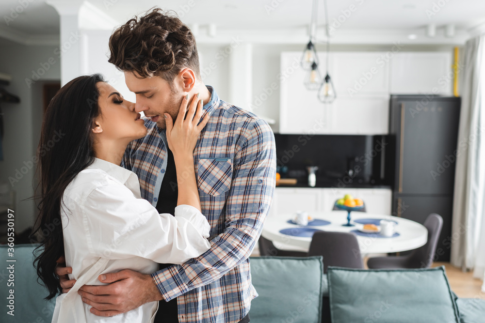 Beautiful woman kissing and touching handsome man at home Beautiful woman kissing and touching handsome man at home