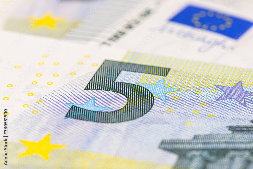 Macro shot of a European Union banknote of 5 EUR, close-up of the number five.
