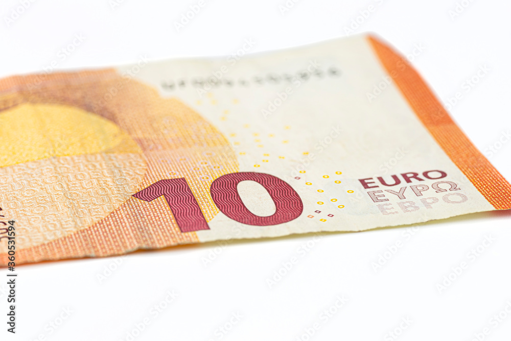 Obraz premium Macro shot of a European Union banknote of 10 EUR, close-up of the number ten, isolated on a white background, selective focus.