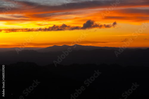 Sunset colours in the sky above silhouetted mountains in the city of Aizawl in Mizoram.