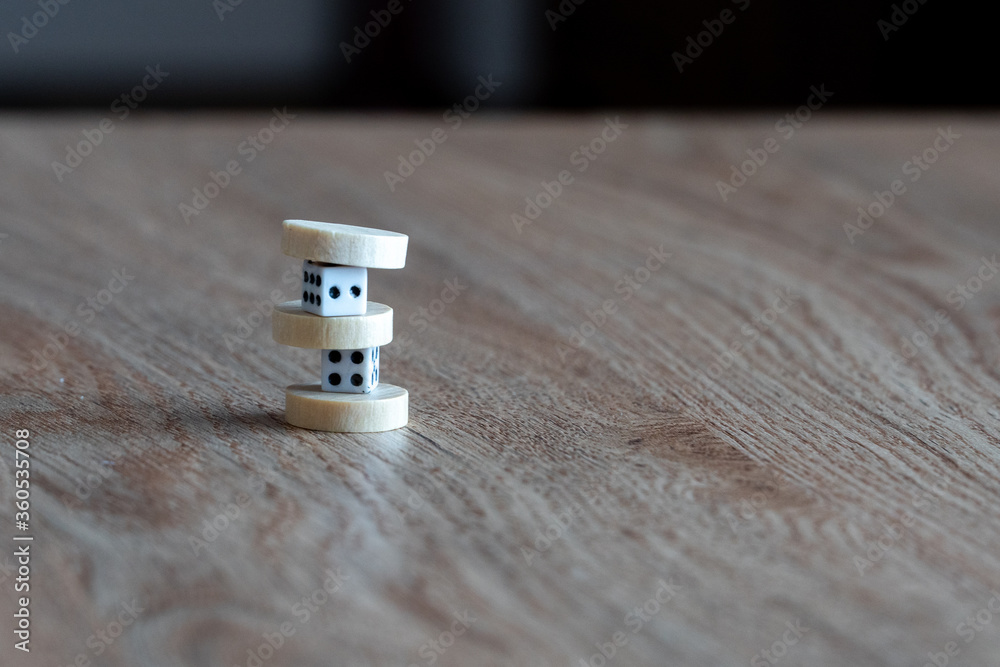 Two plastic dice and backgammon chips on a table.