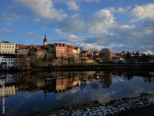 view of the old pisek town over the river with reflection and clouds during sunny day