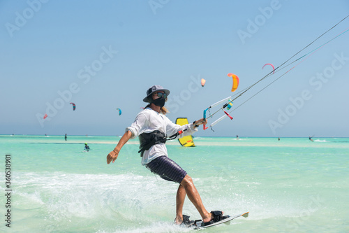 kiter rides on a background of transparent water and blue sky