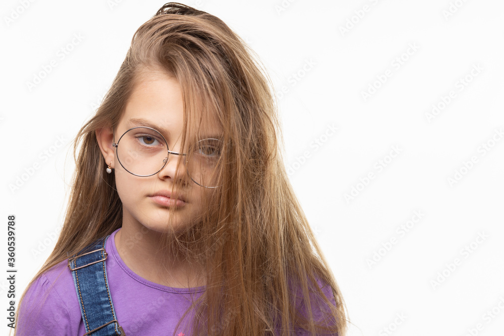 Portrait of a girl of eleven years on a white background with an original hairstyle