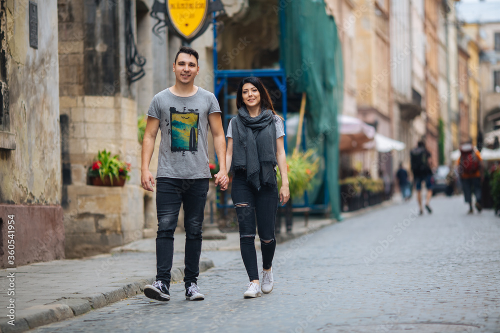 couple posing on the streets of a European city in summer weather.