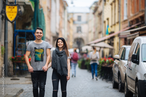 A couple in love slowly walks the streets of the city on a cool autumn morning.