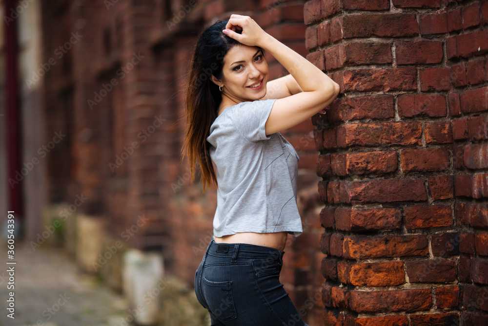 girl in a gray T-shirt smiling in the city
