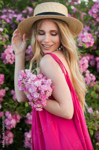 Beautiful woman in pink dress and blond long hair collect pink roses. Beauty and fashion © darkfreya