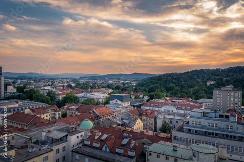 Aerial view of Ljubljana city at sunset. Colorful golden hour over city buildings with hills in the distance. Capital city of Slovenia in summertime. Colorful clouds in the sky