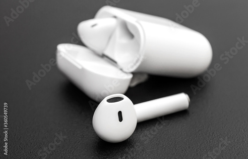 Bluetooth headphones with box on black background.